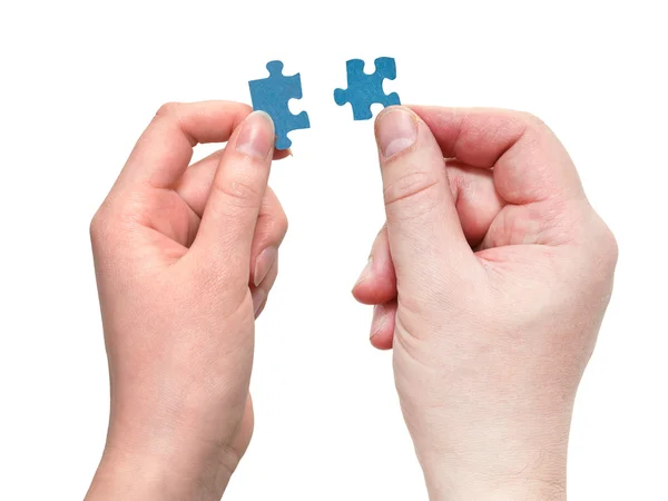 Mannelijke en vrouwelijke handen met kleine puzzelstukjes — Stockfoto
