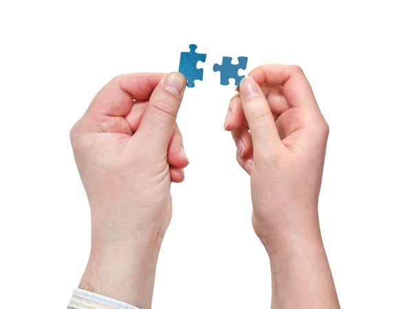 Küçük puzzle parçaları ile erkek ve dişi el — Stok fotoğraf