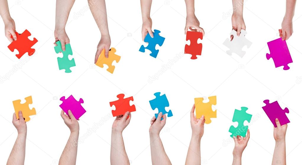 set of color puzzle pieces in people hands