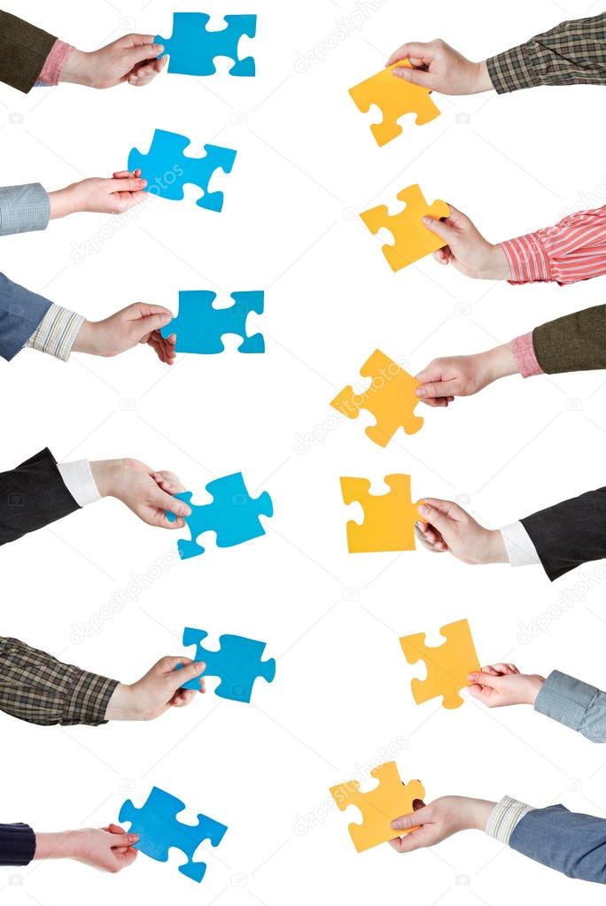 yellow and blue puzzle pieces in people hands