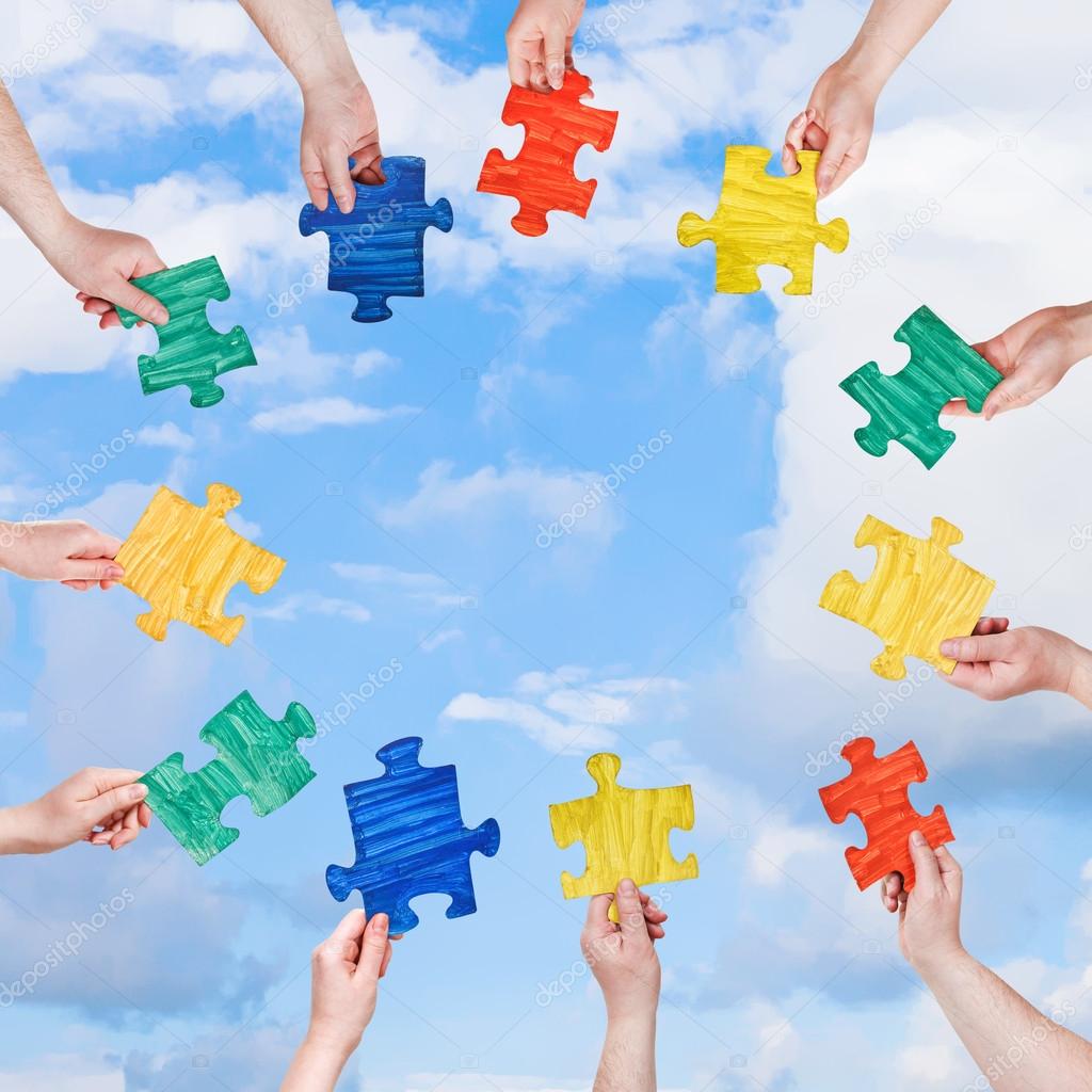 people hands with puzzle pieces with blue sky