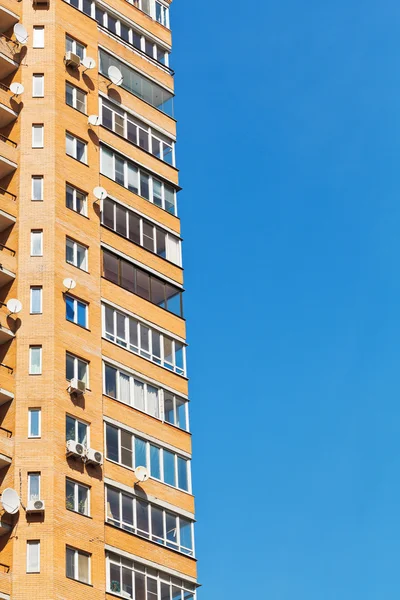 Blauwe hemel en muur van baksteen multistoried huis — Stockfoto
