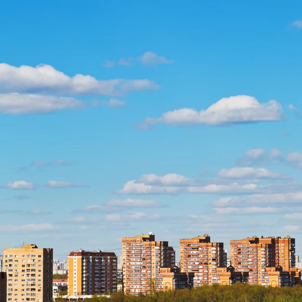 Nuages dans le ciel bleu sur les maisons d'appartements en briques — Photo