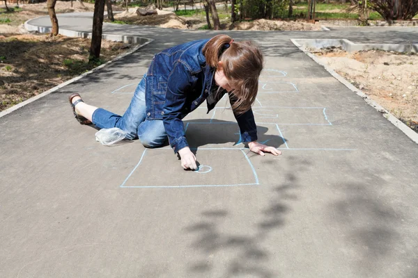 Girl drawing hopscotch outdoors — Stock Photo, Image