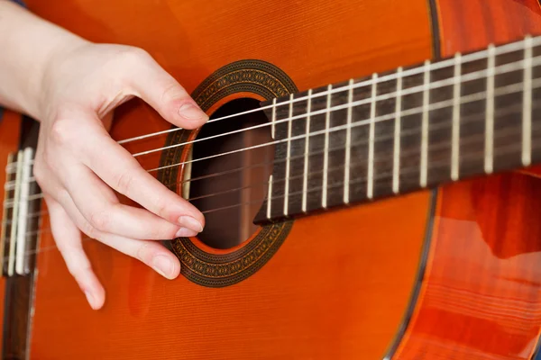 Mão feminina tocando guitarra acústica — Fotografia de Stock