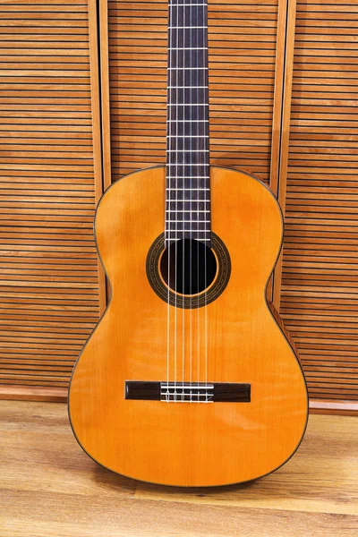 Classical acoustic guitar near wall — Stock Photo, Image