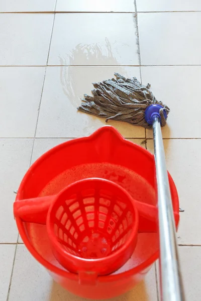 Dweilen de tegelvloer door doekje en rode emmer — Stockfoto