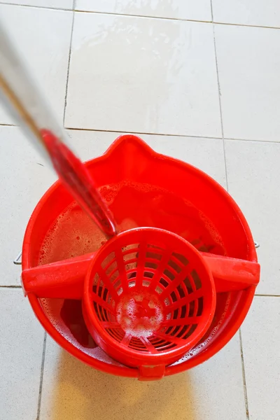 Esfregona em balde vermelho com água espumosa — Fotografia de Stock