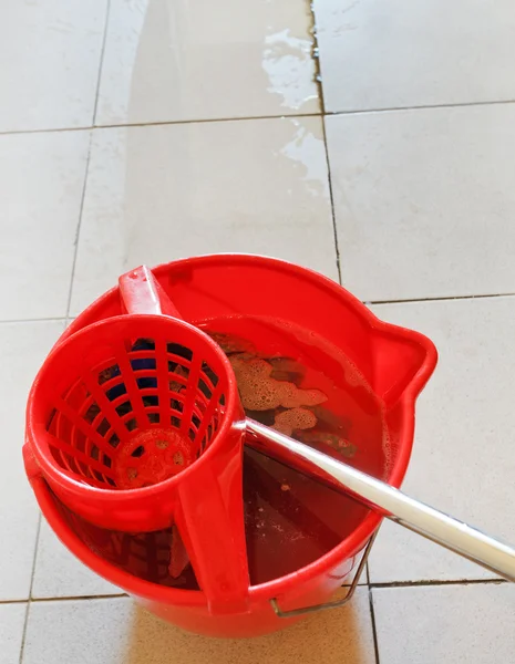 Swab in red bucket with washing water — Stock Photo, Image