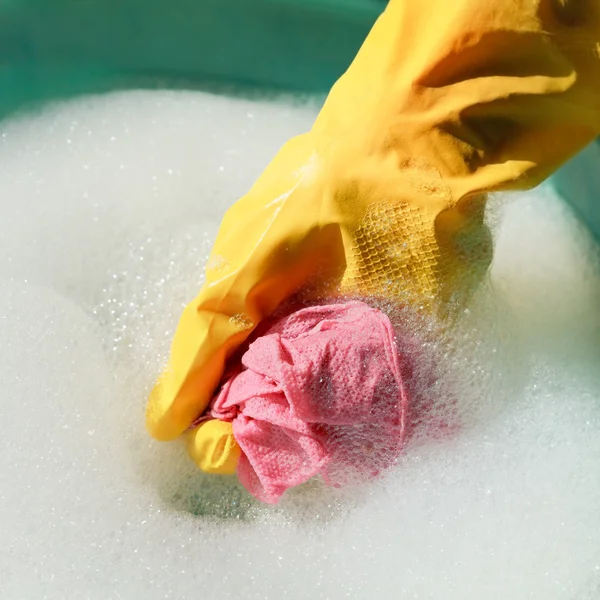 Ręka w żółty gumowe rękawice płukania mokre prochowiec — Zdjęcie stockowe