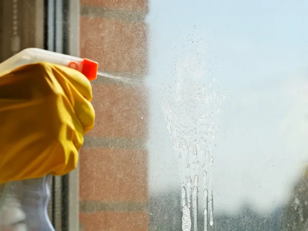 Soapy jet from spray bottle on window glass — Stock Photo, Image