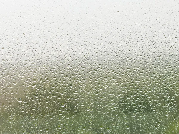 Gotas de lluvia en el panel de la ventana del hogar — Foto de Stock