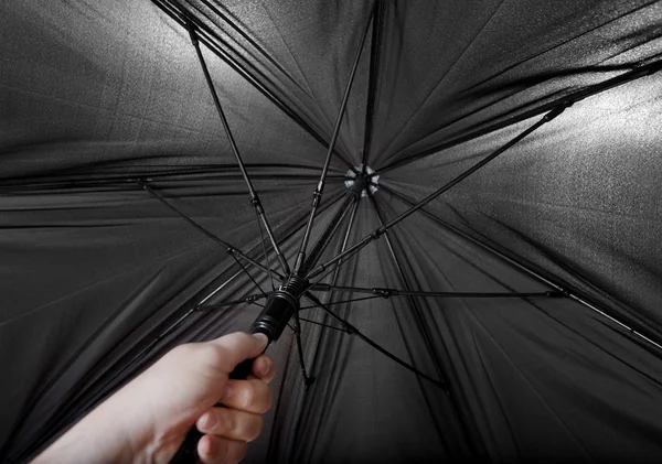 Hand opens big black umbrella — Stock Photo, Image