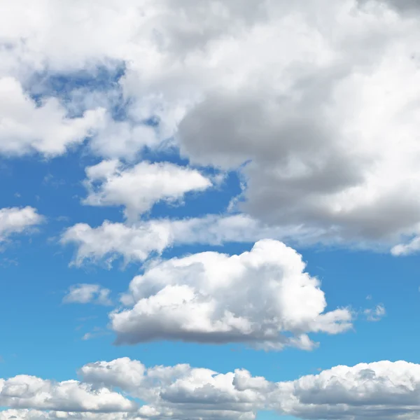 Пухнасті хмари в синьому полуденному небі — стокове фото