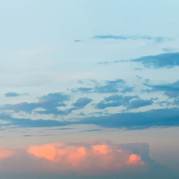 Pink fluffy clouds in blue sunset sky — Stock Photo, Image