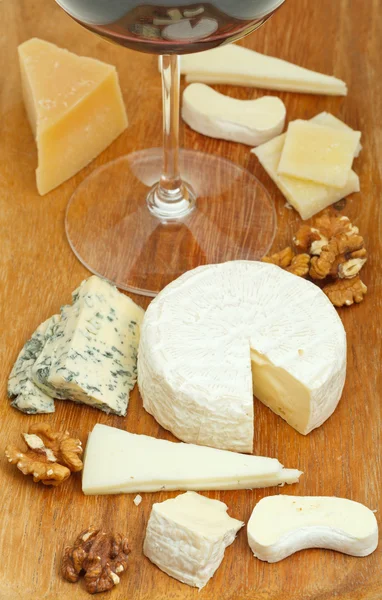 Copo de vinho tinto e sortimento de queijos — Fotografia de Stock