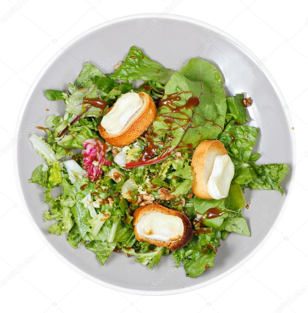 top view of green salad with goat cheese on plate