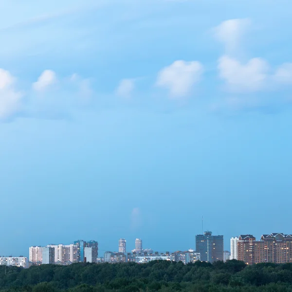 Fluffy cloud in blue dusk sky over city — Stock Photo, Image