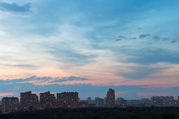 Durk blauwe en roze nacht sky over stedelijke straat — Stockfoto