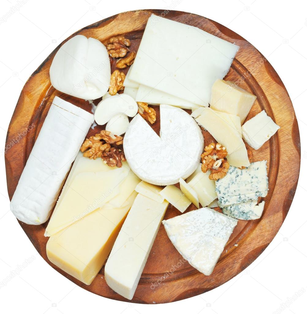 top view of wooden plate with various cheeses