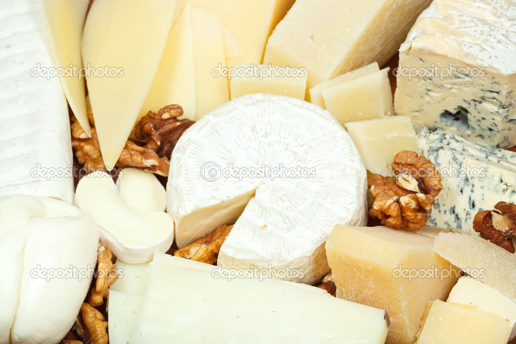 assortment of sliced cheeses and walnuts