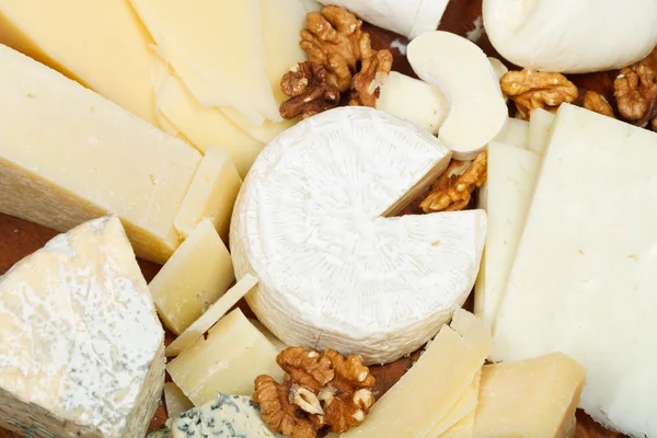 Assortment of cheeses on wooden plate — Stock Photo, Image