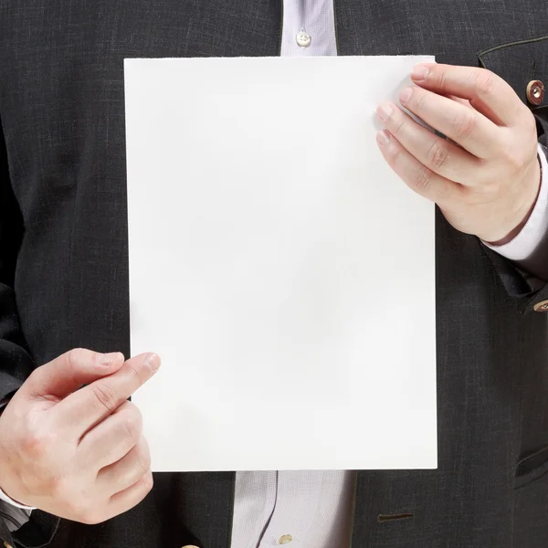 Salesman holds blank sheet of paper in hands — Stock Photo, Image