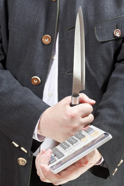 Calculadora y cuchillo en manos de hombre de negocios — Foto de Stock