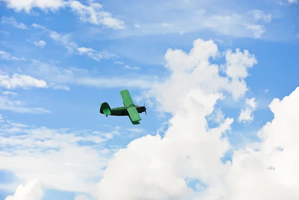 Pequeno avião verde voando no céu azul — Fotografia de Stock
