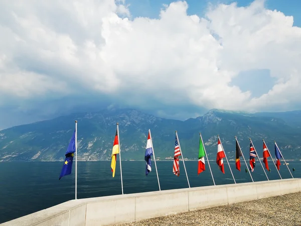 Flags of European countries over Garda lake — Stock Photo, Image