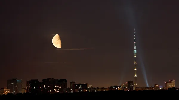 Media luna sobre la torre de televisión y la ciudad en la noche de verano —  Fotos de Stock