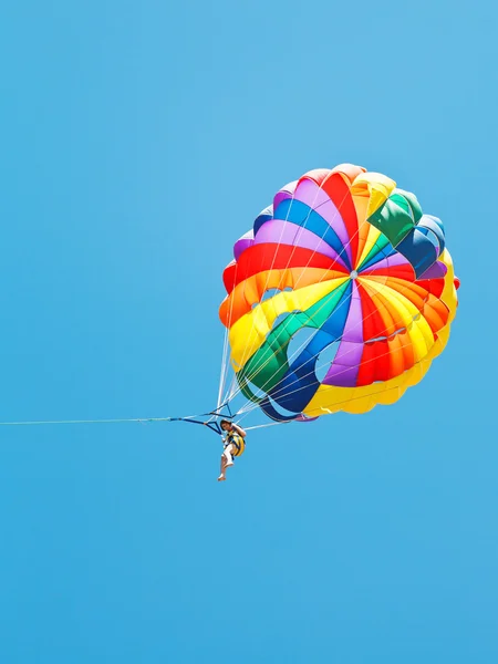 Menina parakiting em paraquedas no céu azul — Fotografia de Stock