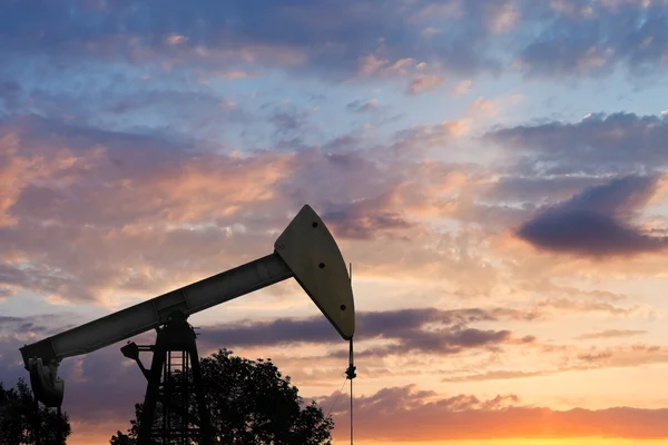 Blick auf den Pumpjack, der Öl bei Sonnenuntergang pumpt — Stockfoto