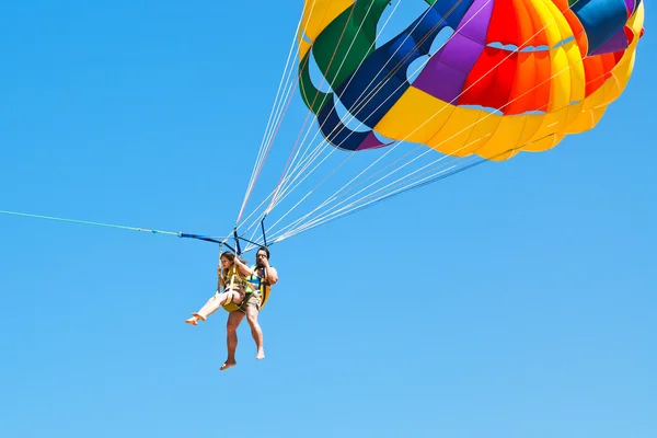 Pessoas parakiting em paraquedas no céu azul — Fotografia de Stock