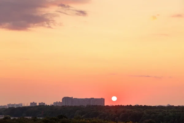 Soleil au-dessus de l'horizon pendant le lever du soleil rouge sur la ville — Photo