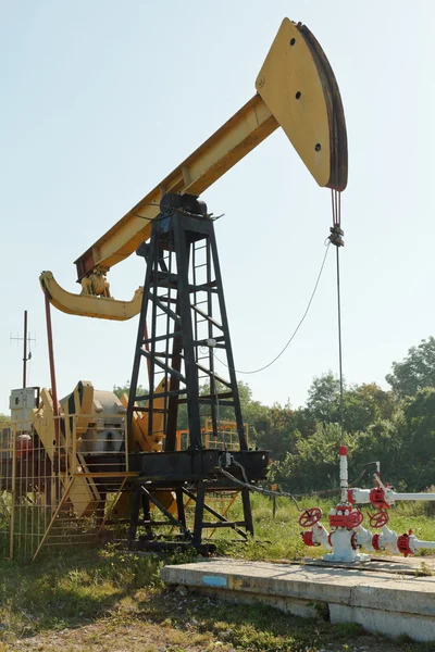 Pumpjack pumps oil in foothills of Caucasus — Stock Photo, Image