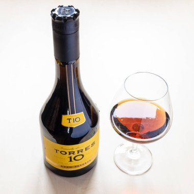 Moskova, Rusya - 16 Ekim 2021: TORRES Gran Reserva 10 İspanyol brendisi ve şarap kadehiyle şişe. Torres 10 Gran Reserva, 1946 'dan beri üretilen en popüler İspanyol brendisidir.