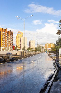 Moskova, Rusya - 4 Eylül 2021: Güneşli sonbahar gününde yağan yağmurdan sonra Moskova 'nın Koptevo ilçesindeki Bolshaya Akademicheskaya Caddesi' nin ıslak karayolu manzarası