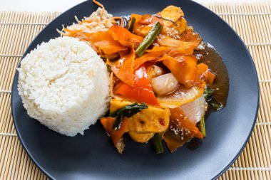 Com Dau Phu Vietnamlı kızarmış tofu ile tatlı ve ekşi soslu sebze ve ahşap tabakta kaynamış pirinç.