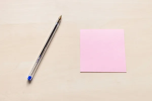 Widok Góry Puste Różowy Arkusz Papieru Notatkowego Niebieski Długopis Jasnobrązowej — Zdjęcie stockowe
