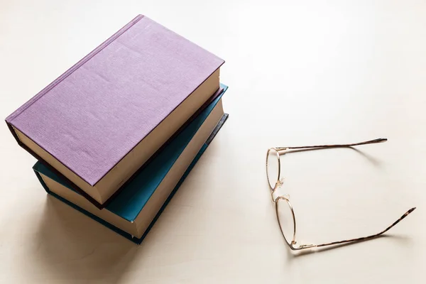 Draufsicht Auf Brillen Und Zwei Dicke Bände Bücher Auf Hellbrauner — Stockfoto