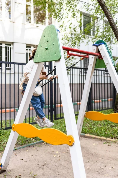 Κορίτσι Αιωρείται Στην Αλυσίδα Swing Στην Αυλή Της Πόλης Την — Φωτογραφία Αρχείου