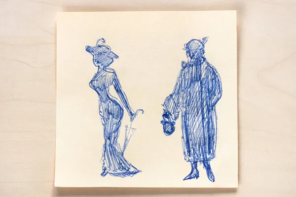 用蓝色圆珠笔在浅褐色桌子上绘制的10世纪和20世纪20年代流行的女性轮廓草图 — 图库照片