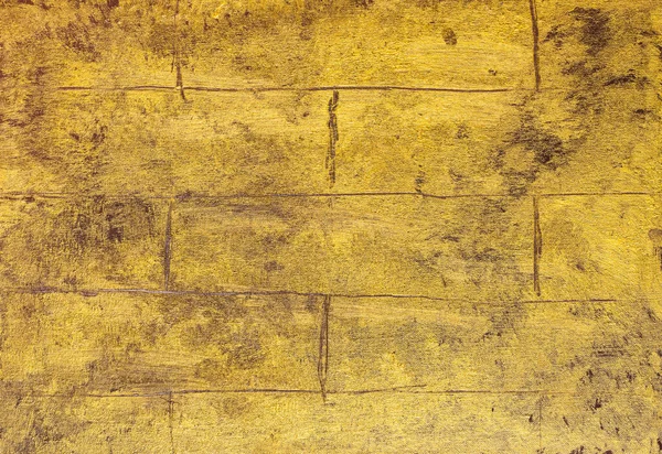 Altın sarısı boyalı tuğlalardan bir duvar. Tablo üzerine akrilik çizilmiş bir el.