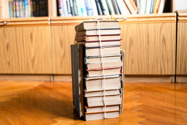 Stapel Gebrauchter Bücher Mit Packfaden Auf Parkettboden Neben Bibliotheksschrank Wohnzimmer — Stockfoto