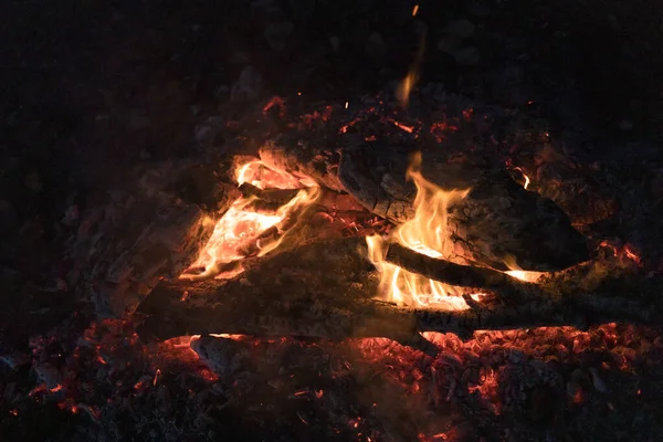 燃烧的原木之间的火焰喷射器在夜间接近室外 — 图库照片