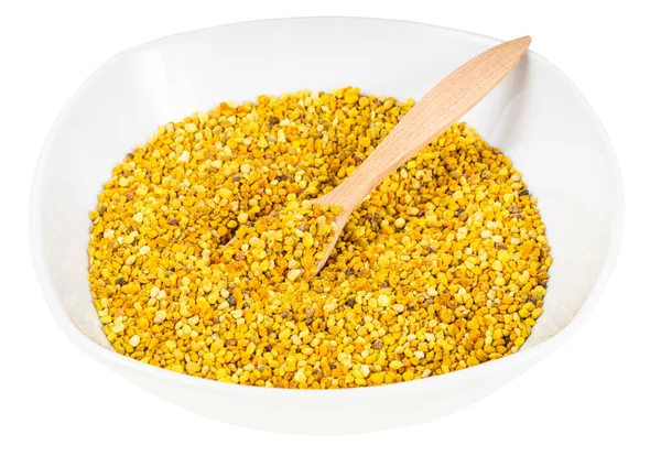 Tahta kaşıklı seramik kase ve beyaz arka planda izole edilmiş doğal arı poleni.