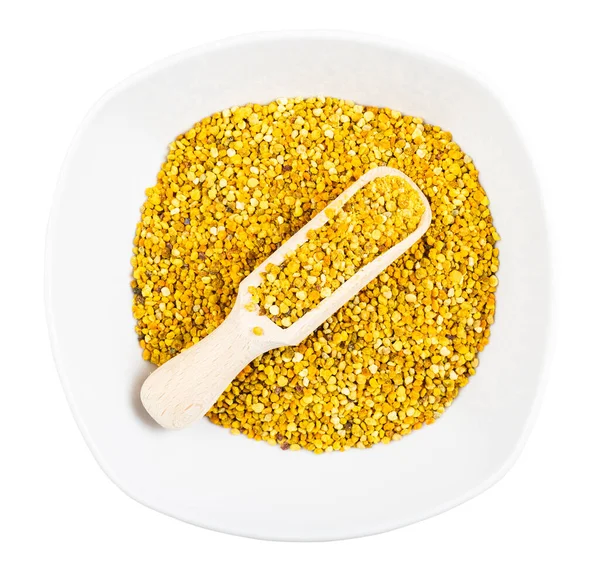 Tahta kepçeli seramik kasenin üst görüntüsü ve beyaz arka planda izole edilmiş doğal arı poleni