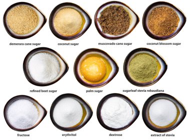 Beyaz arkaplanda izole edilmiş seramik kâselerdeki isimlerle çeşitli şekerler.