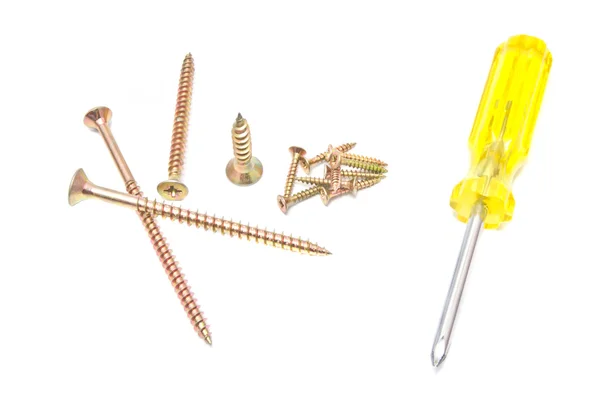 Different yellow screwdriver and golden screws on white — Stock Photo, Image